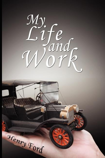 Paperback of "My Life and Work" autobiography by Henry Ford with a plain cover and visible title, placed on a wooden surface.